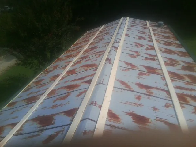 Rusted metal roof panels with new wood purlins before replacement — Storm Damage Roof Repair in Tuttle by Roofing Brothers