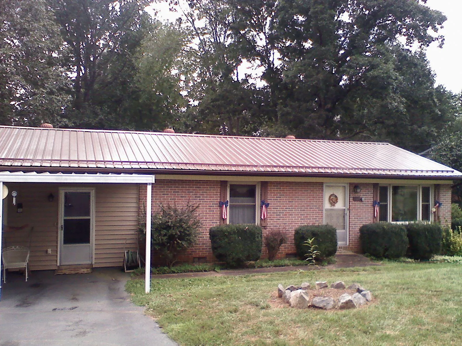Bronze metal roof and carport on a brick ranch home — Roof Repair work by our crew in Tuttle