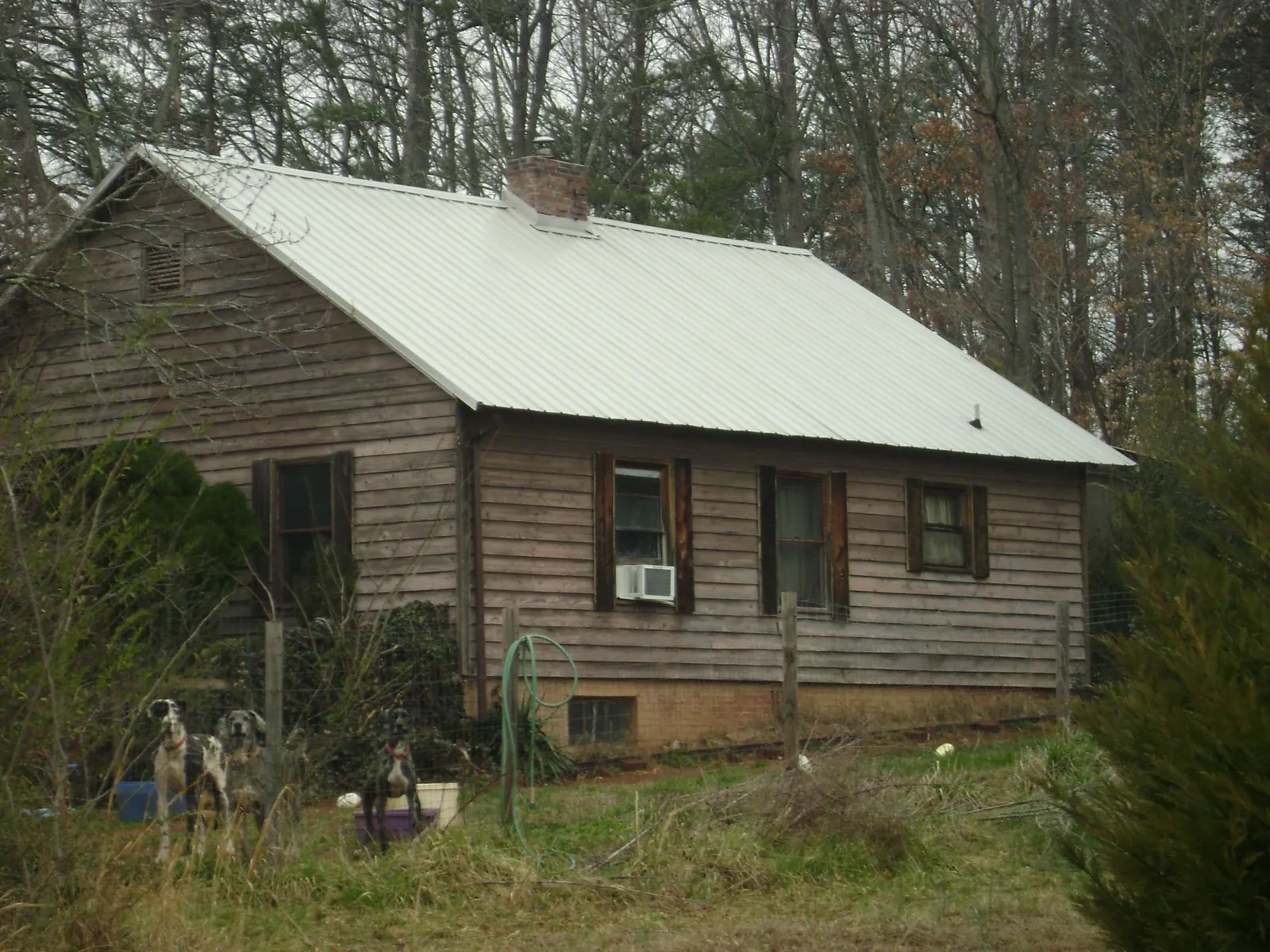 White metal roof on an old wood sided farmhouse, from a Asphalt Shingle Roof Repair job in Tuttle